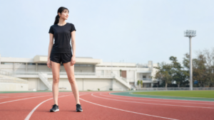高身長女子が陸上トラックで前向きに立つアイキャッチ
