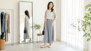 高身長女子が背を低く見せるより柔らかく見える服装を鏡で確認する女性