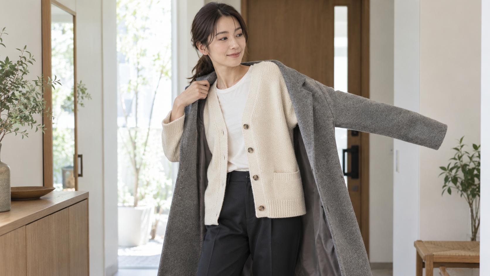 カーディガンの上にコートを羽織る女性